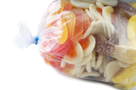 plastic bag full of colorful candies on white backgroundの写真素材
