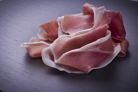 Raw ham leg sliced on the slateの写真素材