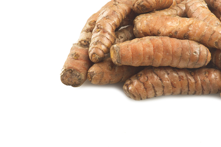 turmeric root and some slices on a white backgroundの写真素材