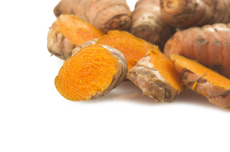 turmeric root and some slices on a white backgroundの写真素材