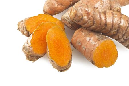 turmeric root and some slices on a white backgroundの写真素材