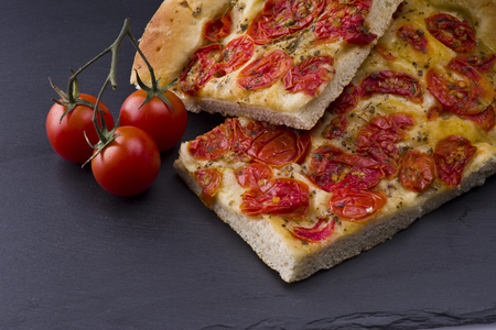 white pizza with tomatoes on the slate stone backgroundの写真素材