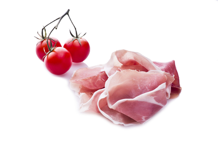 Raw ham leg sliced  with three tomatoesの写真素材