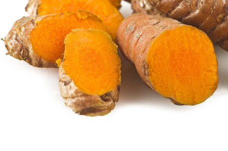 turmeric root and some slices on a white backgroundの写真素材