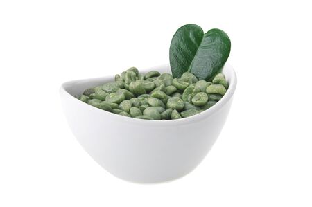 White bowl with green coffee beans on the whiteの写真素材
