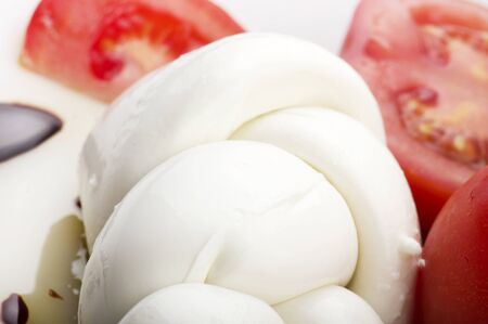 Mozzarella tomatoes and fresh salad on the whiteの写真素材