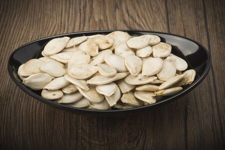 Dried pumpkin seeds on the wood tableの写真素材