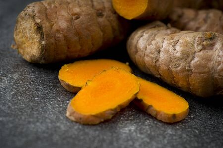 turmeric slices close up on gray backgroundの写真素材