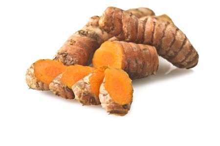 turmeric root and some slices on a white backgroundの写真素材