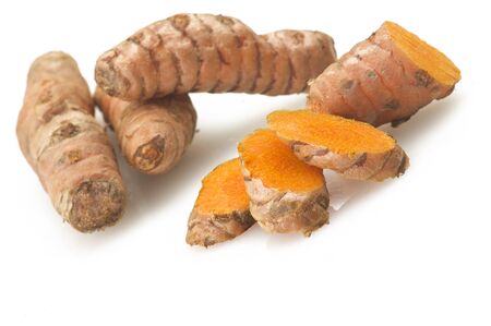 turmeric root and some slices on a white backgroundの写真素材