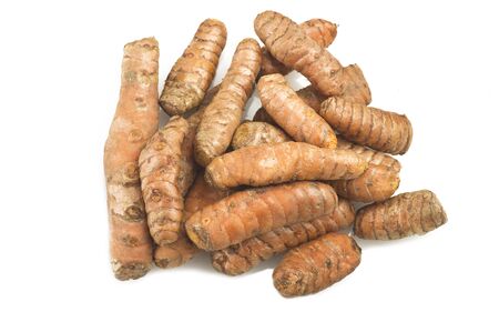 turmeric root and some slices on a white backgroundの写真素材