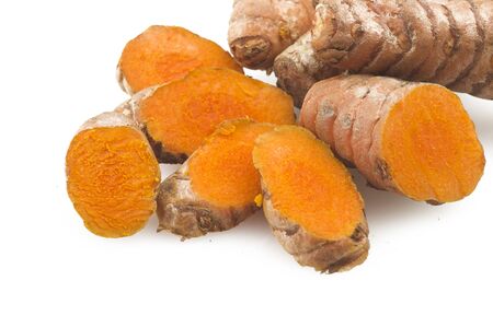 turmeric root and some slices on a white backgroundの写真素材
