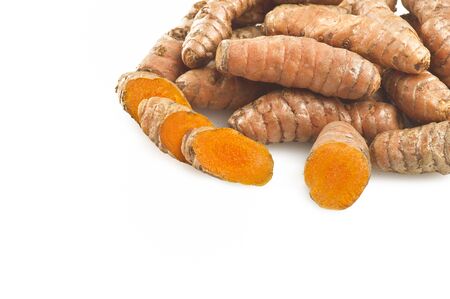 turmeric root and some slices on a white backgroundの写真素材