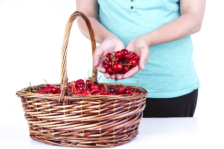 woman showing some cherries from a basketの写真素材