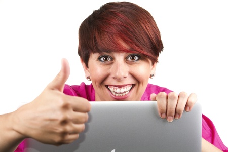 Smiling business woman using laptop and doing thumbs upの写真素材