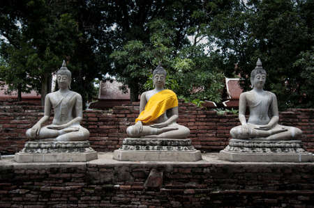 old thai's style of buddha statue in black&white shot with yellow cover flabricの写真素材