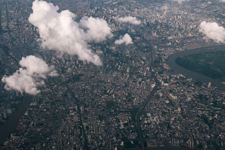 Bangkok city's bird eye view shot from a plane that flight in a morning with warming color of sunrise and some shade from clouds 
photo may had some noise and partly blurの写真素材