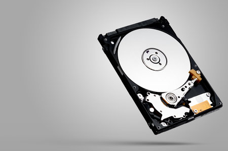a computer's hard disk hdd data storage drive without shield isolated  in white background show magnetic disc and electronic part insideの写真素材