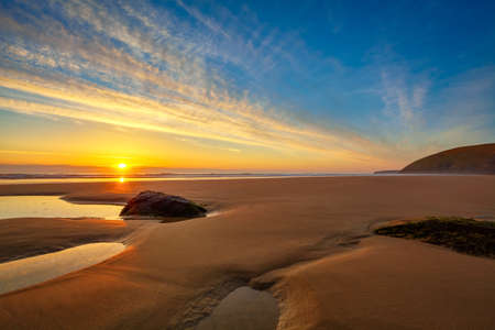 Beautiful pristine beach in Cornwall that glows golden in the sunlight.