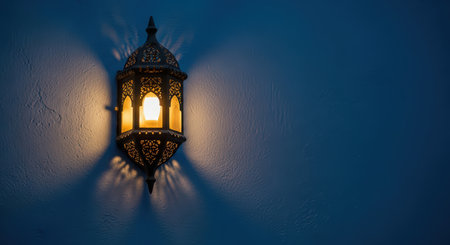 Ornate moroccan lantern casting soft glow on blue wallの素材