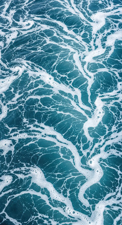 Intricate patterns of ocean waves and foam on a turquoise sea surfaceの素材