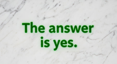 Green stencil text 'the answer is yes' on white marble backgroundの素材