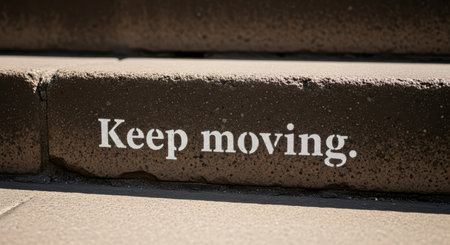 Inspirational message stenciled on urban steps encouraging progress and perseveranceの素材