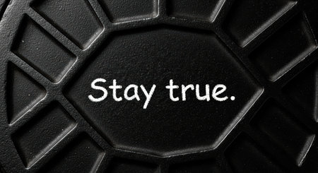 Stay true message on textured black surface close-upの素材