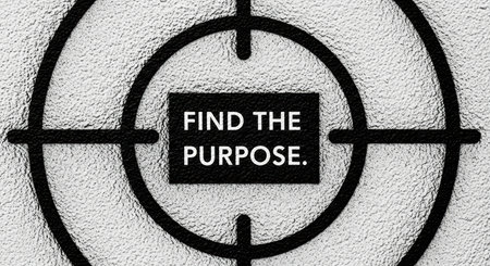 Close-up of target with motivational text 'find the purpose' on textured surfaceの素材