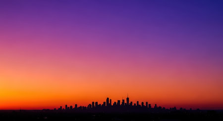 Colorful urban skyline silhouette against vibrant sunsetの素材