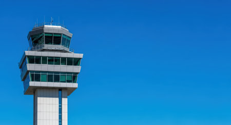 Modern air traffic control tower against clear blue skyの素材
