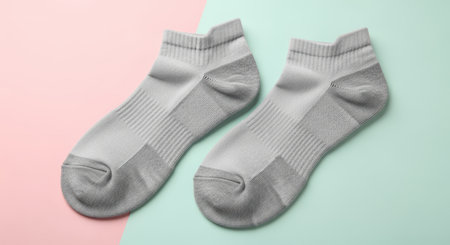 Pair of gray ankle socks on colorful background with pink and mint greenの素材