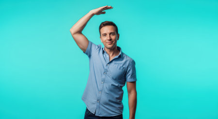 Young caucasian male gesturing height against turquoise backgroundの素材