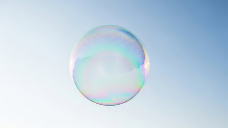 Single iridescent soap bubble floating against clear blue skyの素材