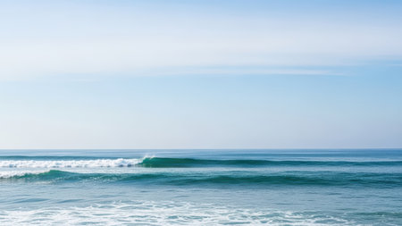 Serene ocean waves under clear blue sky at sunrise.の素材