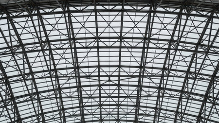 Curved steel and glass structure of atrium roof showcasing modern architecture.の素材