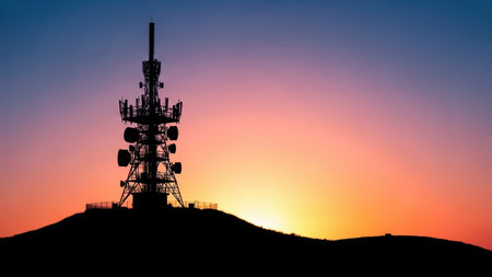 Silhouette of transmission tower against vibrant sunset skyline.の素材