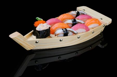 Assortment of rolls served on small wooden boatの写真素材