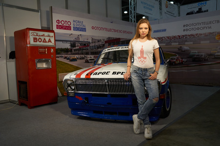 Moscow Crocus Expo, Moscow, Russia - April 15, 2016: Girl stands near old car at Photoforum 2016のeditorial素材