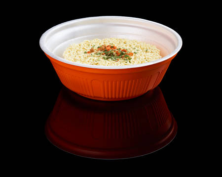 Instant noodles in plastic plate isolated on black reflecting backgroundの写真素材