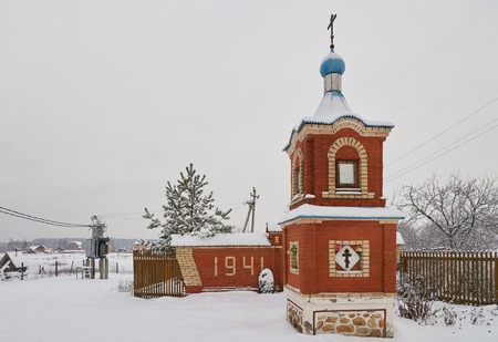 Winter view of red brick chapel and monument to soviet warriors who died in Second World War. Ignatovo village, Pavlovo-Posadskiy district, Moscovskaya oblast, Russia.の写真素材