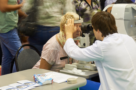 All-Russian Exhibition Center, Moscow, Russia - August 23, 2017: Healthy lifestyle exhibition where Moscovites could make health check free of charge. Ophthalmologist checks the eye of the womanのeditorial素材
