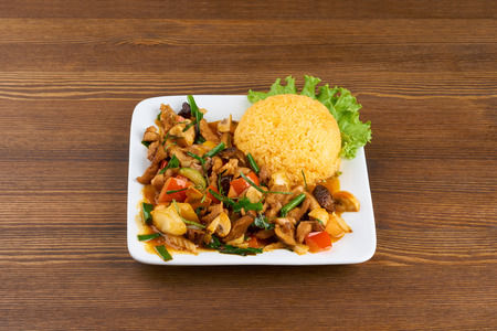 Vietnamese meal on wooden brown table. Fried mushrooms, meat, vegetables and rice.の写真素材