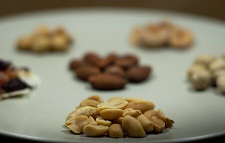 Different kinds of nuts in white dish Almonds, Pistachios, Cashews, peanut, hazelnut, Dry Fruitsの写真素材