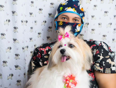 woman in dog groomer uniform with Shih Tzu pet