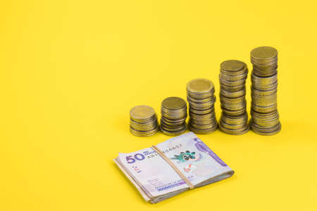 Concept of saving money, coins and banknotes isolated on yellow background