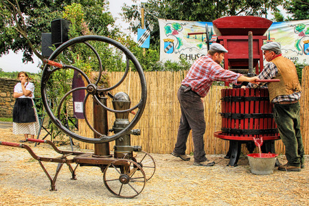 CHUSCLAN, FRANCE - October12, 2013: Traditional Wine Pressing using a manual grape crushing machine during the festival grape harvest of the history October 12 and 13, 2013, in Chusclan, France.のeditorial素材