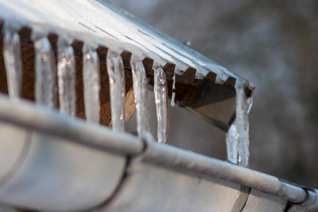 Icicles falling into the roof of the gutterの写真素材