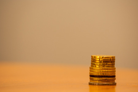 Close up of stacked euro coins on a table, bright backgroundの写真素材