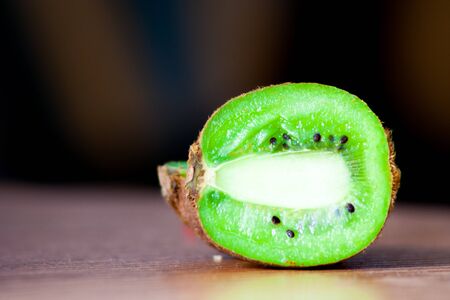 Close-up of kiwi cut in half, lying on the table, black backgroundの写真素材